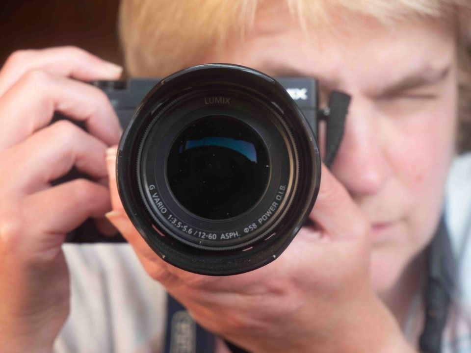 Fiona Robinson holds a camera, with the lens in focus.